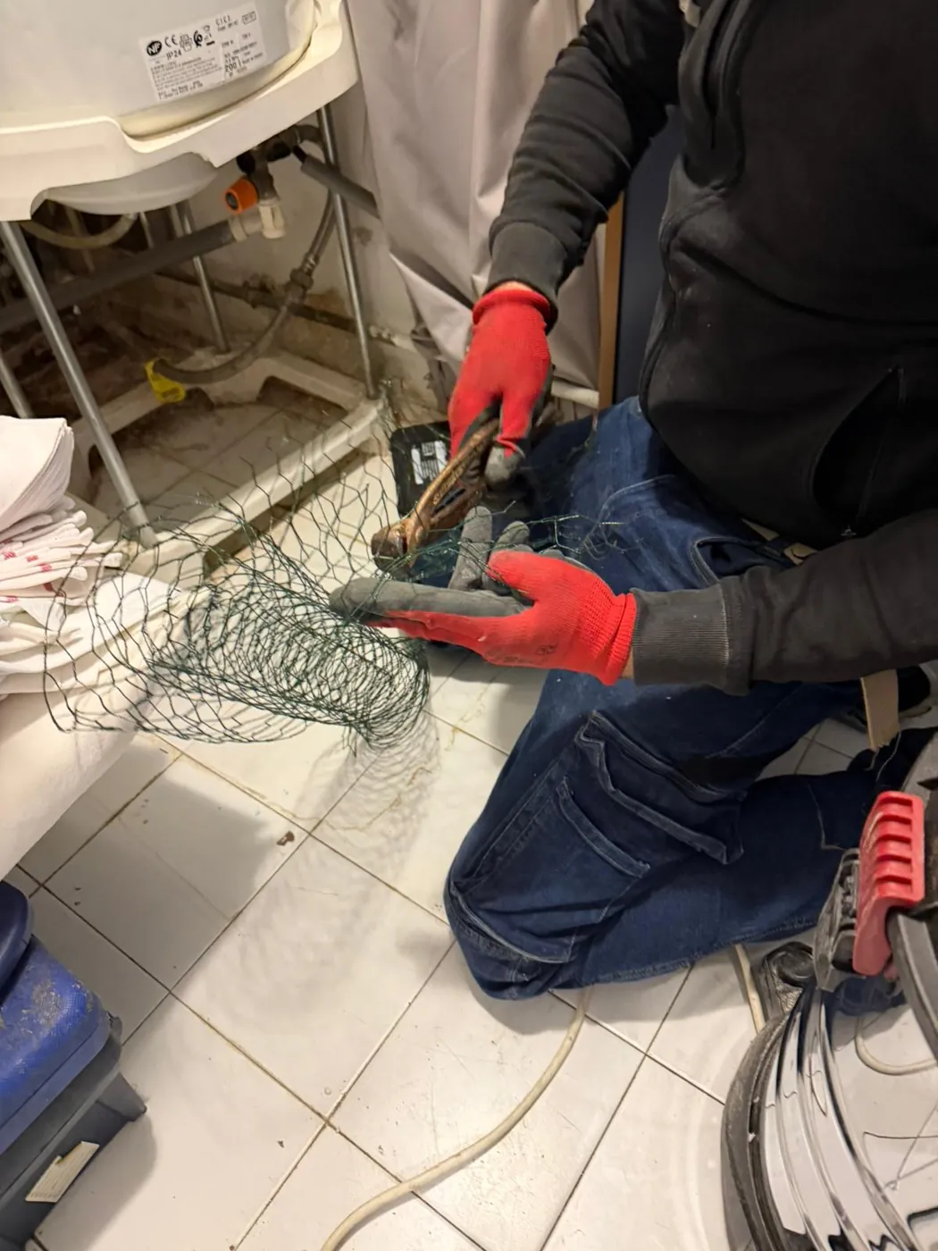 Technicien Nuisibles Chrono posant un grillage métallique dans un restaurant à Aubagne