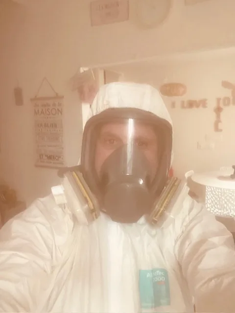 Technicien en combinaison et masque intégral lors d'un traitement contre les punaises de lit à Rousset